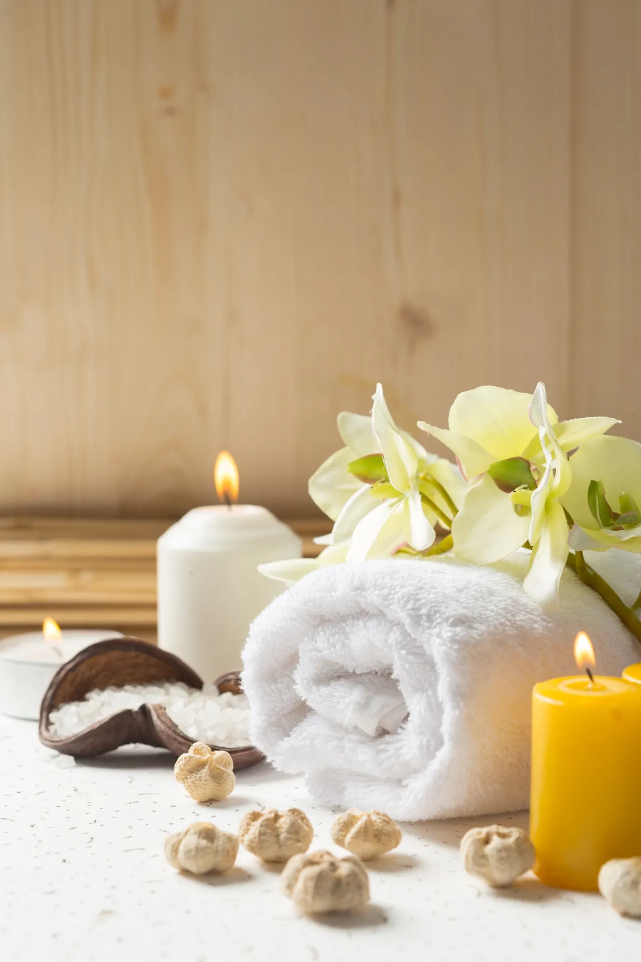 Mumlar ve katlanmış havlularla spa atmosferinde durgun bir kompozisyon